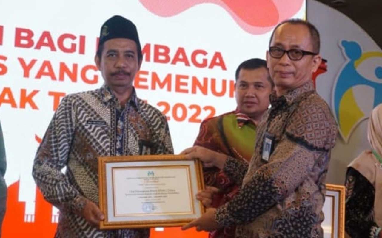 Kepala MTs Negeri 1 Tuban, Ali Maghfur saat menerima penghargaan dari Deputi Perlindungan Khusus Anak, Kementerian PPPA, Nahar di Jakarta, Selasa (21/11/2023).
