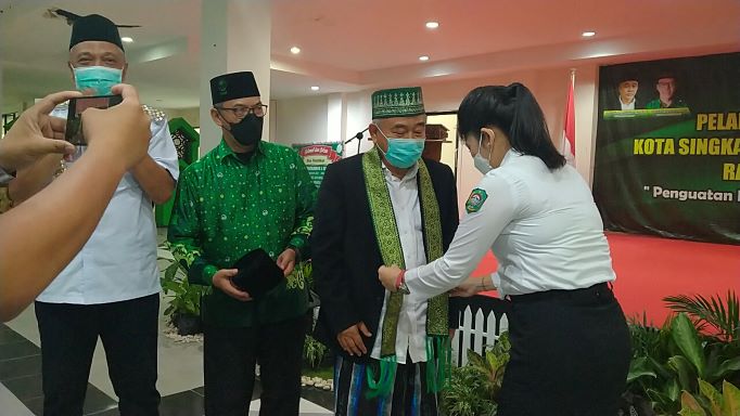 Wali Kota Singkawang Tjhai Chui Mie menganugerahkan simbol kehormatan berupa selendang kepada Prof Dr KH Asep Saifuddin Chalim, MAg dalam acara Pelantikan PC Pergunu Kota Singkawang dan Kabupaten Bengkayang Kalimantan Barat di Kantor Wali Kota Singkawang, Rabu (23/2/2022). Foto: MMA/BANGSAONLINE.com