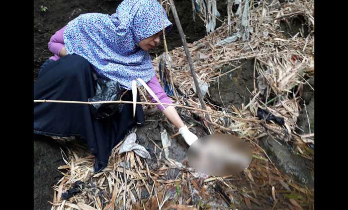 Bidan saat mengvakuasi mayat bayi.