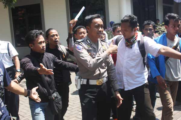Sejumlah mahasiswa saat meminta salah satu petugas kepolisian meninggalkan areal kampus. (foto: BANGSAONLINE)