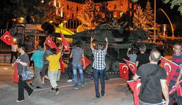 Pendukung Presiden Recep Tayyip Erdogan menghentikan tank milter Turki di depan gedung parlemen di Istanbul, 15 Juli 2016. Militer Turki melakukan kudeta terhadap pemerintahan Erdogan. Kutluhan Cucel/Getty Images/tempo.co