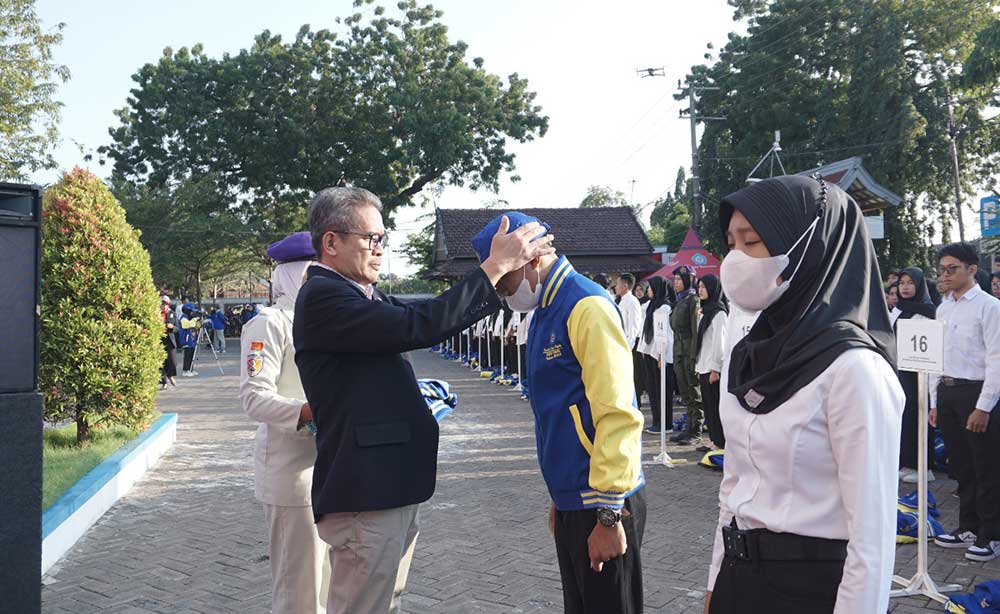 Rektor Unirow Tuban Dr. Warli saat memakaikan identitas KKN kepada perwakilan mahasiswa. Foto: Ist.