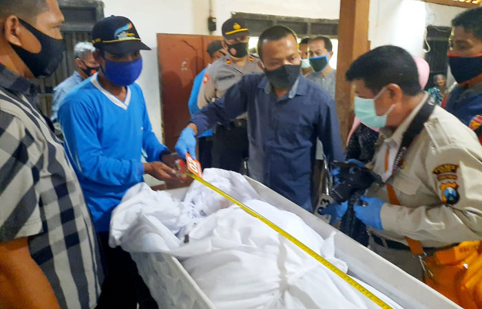 Petugas sedang melakukan pemeriksaan jenazah korban.