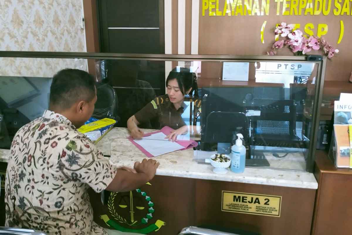Pelapor saat menyerahkan berkas ke petugas Kejaksaan Negeri Ngawi, Selasa (20/12/2022).