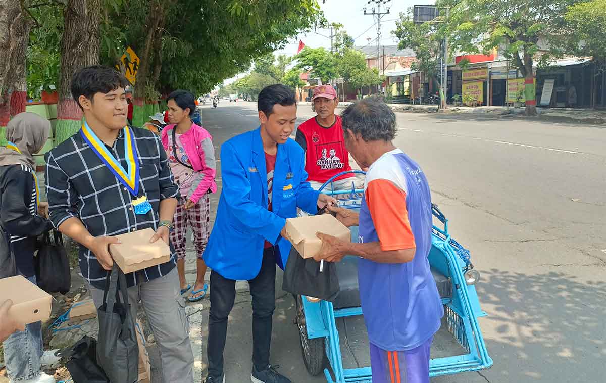 Para mahasiswa saat membagikan sembako dan nasi kota kepada masyarakat di Nganjuk.