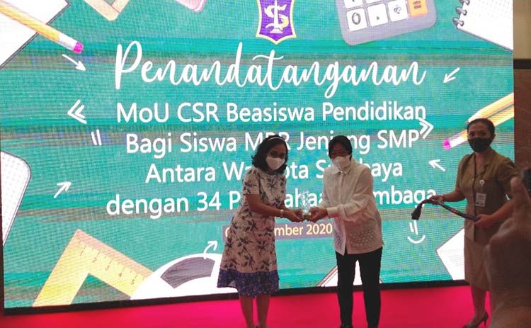 Wali Kota Risma menyerahkan cinderamata kepada salah satu perusahaan / lembaga. (foto: YUDI A/ BANGSAONLINE)