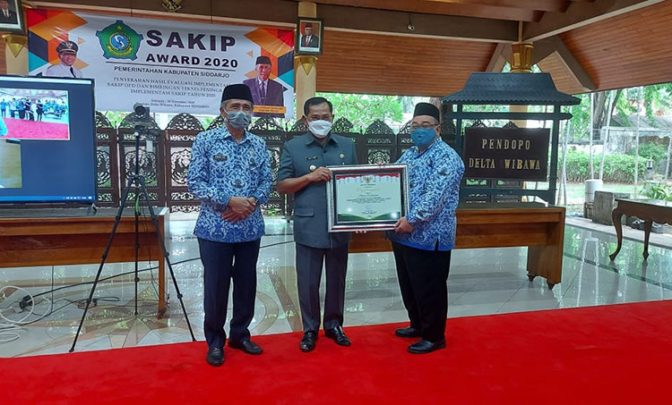 PENGHARGAAN: Pj. Bupati Hudiyono menyerahkan SAKIP Awards kepada Kadis Perikanan Sidoarjo M. Bachruni Aryawan, Senin (30/11/2020). (foto: ist)