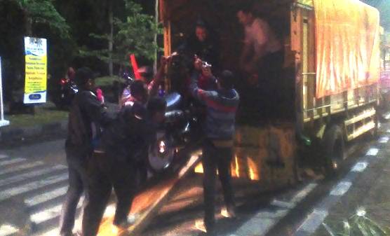 ?ANGKUT – Sejumlah petugas menaikkan motor knalpot brong dan protolan ke atas truk saat pengamanan tahun baru, di Bundaran Taman Pinang, Kota Sidoarjo, Rabu (31/12/2014). foto: nanang ichwan/BangsaOnline