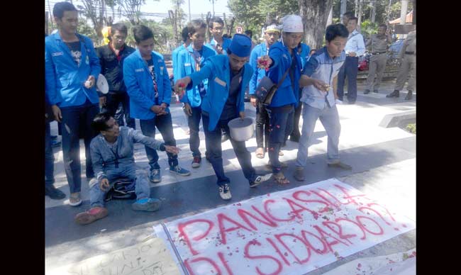 TABUR BUNGA: Mahasiswa PMII Sidoarjo tabur bunga kala demo peringatan kelahiran Pancasila, di depan Kantor DPRD Sidoarjo, Rabu (1/6). foto: MUSTA