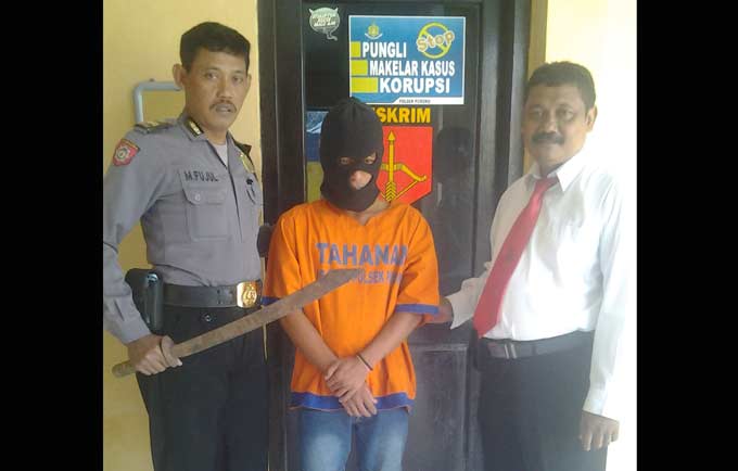 Tersangka Suyatno beserta barang bukti pedang didampingi petugas polsek Porong. 