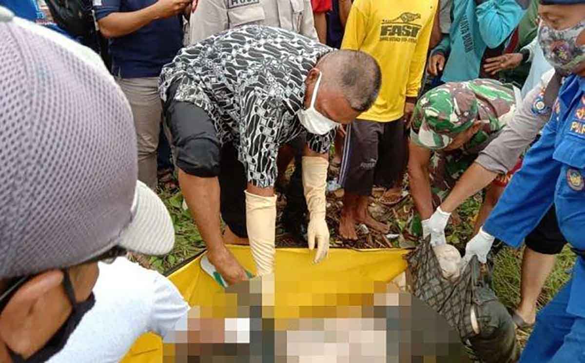 Petugas saat mengevakuasi mayat yang ditemukan warga di pinggir Sungai Bondoyudo, Jember.
