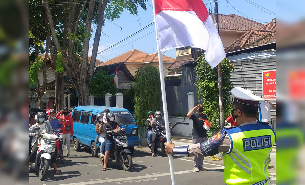 Polisi lalu lintas di Banyuwangi menghentikan semua kendaraan menjelang detik-detik Proklamasi Kemerdekaan Republik Indonesia, di Simpang Lima Banyuwangi, Selasa (17/8/2021).