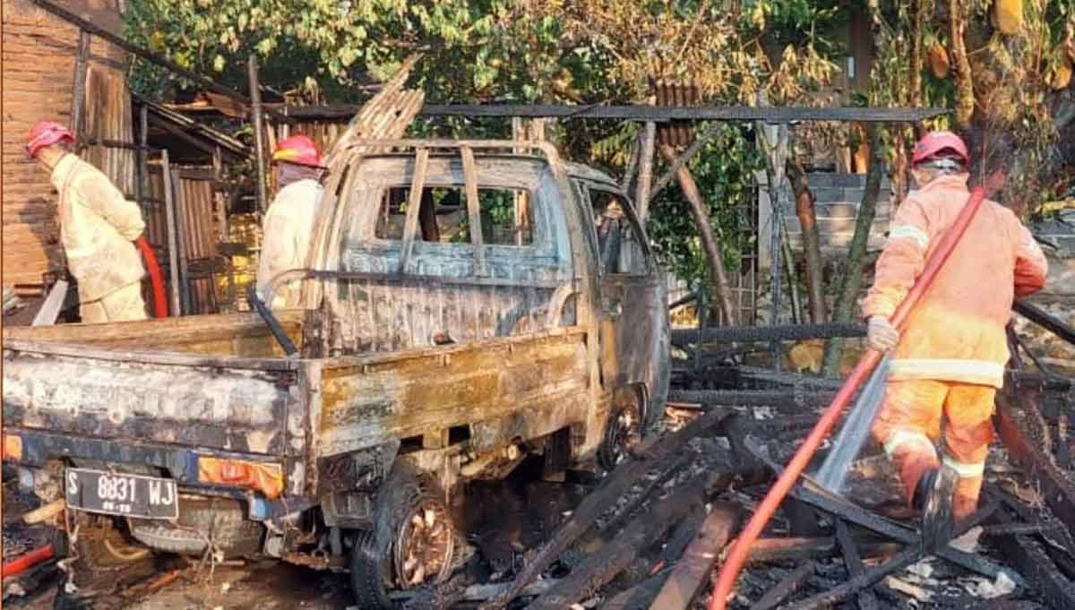 Petugas saat memadamkan api yang menghanguskan mebel di Jombang.