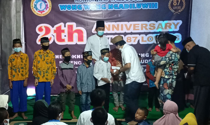 Gus Nafan saat menyerahkan santunan kepada anak yatim-piatu disaksikan oleh Presiden 87 Lovers, Hari Kurniawan. foto: MUJI HARJITA/ BANGSAONLINE