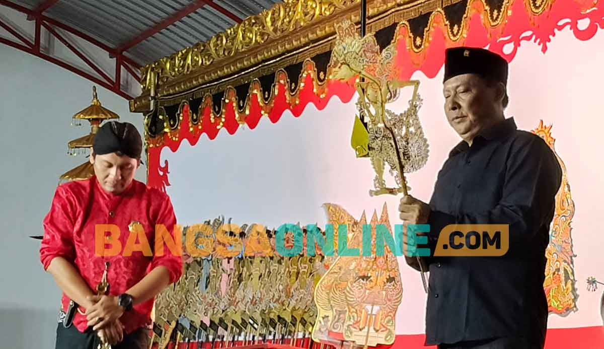 Ketua DPC PDIP Kabupaten Kediri, Murdi Hantoro, saat memegang tokoh wayang sebelum diserahkan ke Ki Didik Wibisono. Foto: MUJI HARJITA/BANGSAONLINE