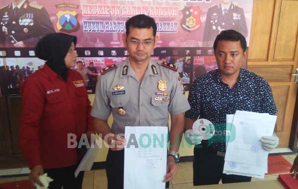 Petugas menunjukkan barang bukti rekaman penangkapan dan sejumlah uang hasil pungutan liar. foto: GUNAWAN/BANGSAONLINE