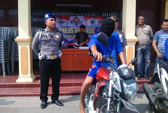 KAWAL: Salah satu petugas tampak mengawal pelaku pencurian sepeda motor dengan modus mencabut kabel dibagian stop kontak. foto: Eky Nurhadi/BANGSAONLINE