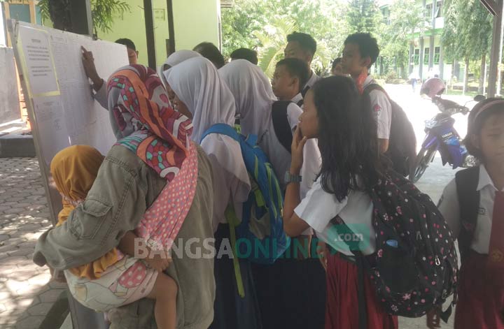 Para siswa SD melihat hasil pengumuman OSN di SMPN 1 Trenggalek. foto: HERMAN S/ BANGSAONLINE