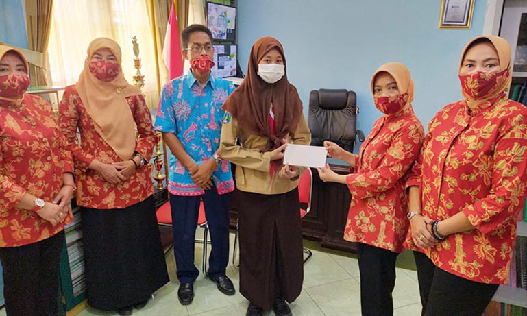 Ny. Aini Zadim Effisiensi saat menyerahkan bantuan kepada siswa SMAN 2 Batu, Kamis (12/11).
