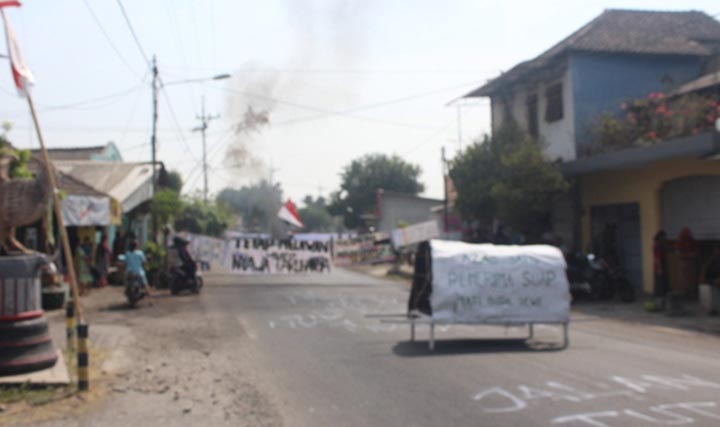 Aksi warga Desa Baujeng menutup akses jalan raya Bangil-Pandaan untuk memprotes bau limbah.