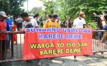 Warga memblokade jalan masuk menuju kandang sapi perah milik H. Suwarno, kemarin foto: dya ayu wulansari/BANGSAONLINE