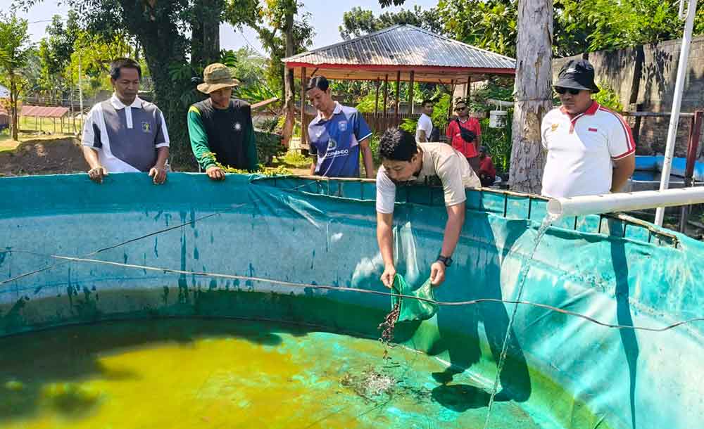 Kepala Lapas Kelas II A Kediri, Solichin, saat menebar bibit lele. Foto: Muji Harjita.