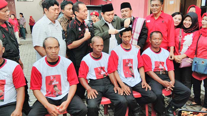 Secara simbolis, Bupati dan Wakil Bupati Nganjuk saat mencukur rambut simpatisan yang akan digundul. foto: BAMBANG/ BANGSAONLINE