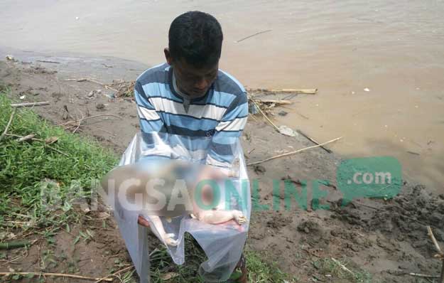 Warga menunjukkan mayat bayi yang ditemukan mengapung di Sungai Bengawan Solo. foto: EKY NURHADI/ BANGSAONLINE