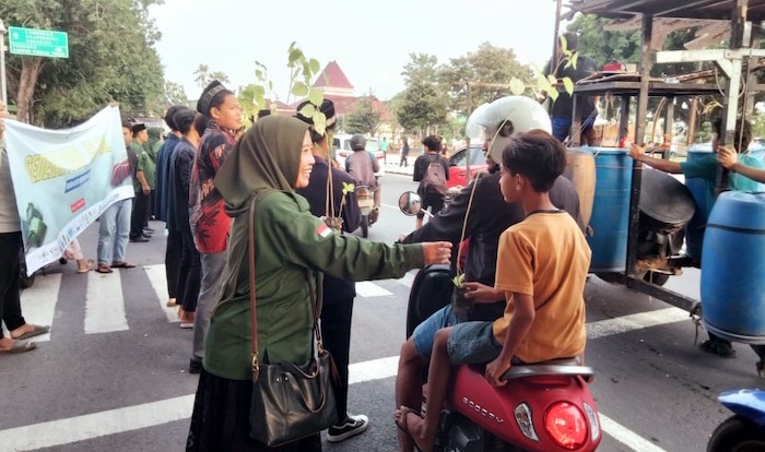 Para peserta kegiatan Eco Ramadhan 2025 saat membagikan bibit pohon kepada pengendara di utara Alun-Alun Tuban