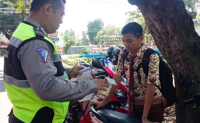 Pelajar SMP yang kena razia polisi dan ditilang karena tak memiliki SIM dan helm di Jl Raden Wijaya Kota Mojokerto, Rabu (11/1).