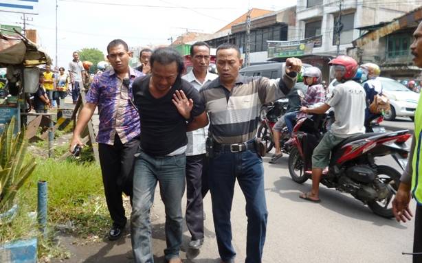 Sudirman (kaos hitam), pelaku gendam digelandang petugas polisi Polsek Porong usai mencoba kabur. Agus HP/BangsaOnline