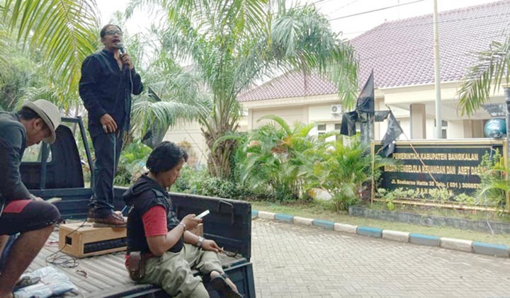 Risang (berdiri di pikap), koordinator aksi saat berorasi meminta Kepala BPKAD dicopot di depan kantor BPKAD Jl. Soekarno Hatta Bangkalan.