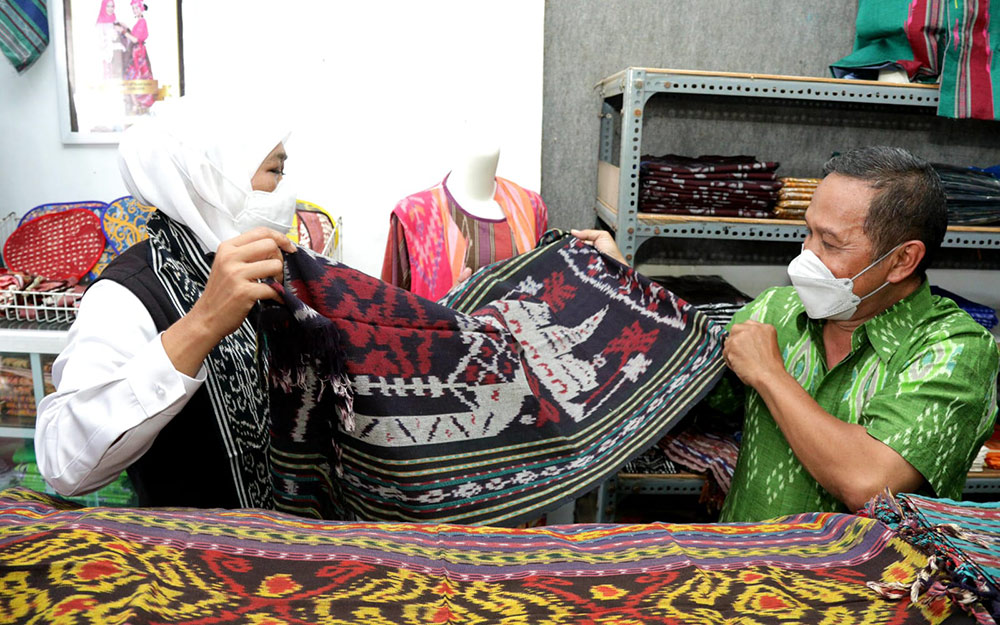 Khofifah dalam sebuah kesempatan meninjau stan yang menjual kain tenun dalam sebuah pameran.