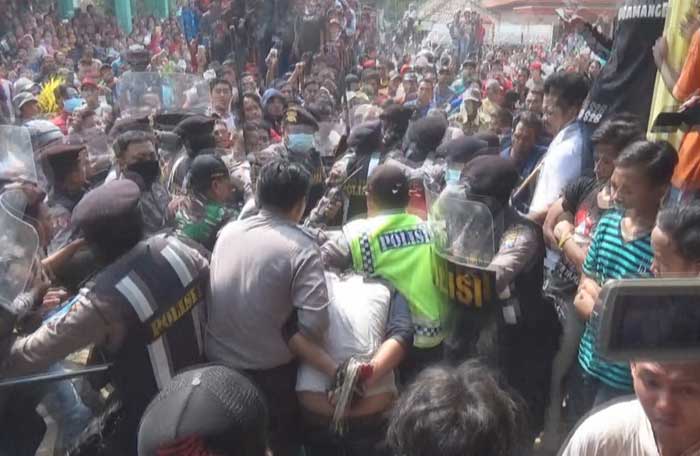 Dua maling saat dievakuasi polisi dari kerumunan warga yang emosi. foto: ROMZA/ BANGSAONLINE