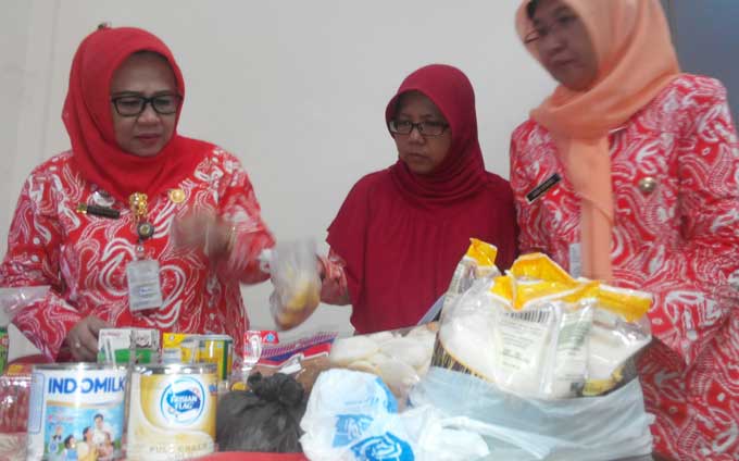 Kadinkes Indah (berkacamata hitam) menunjukkan produk mamin rusak yang didapati dari beberapa supermarket. foto: YUDI EP/ BANGSAONLINE