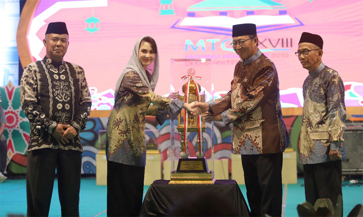 Ketua TP PKK Jatim Arumi Bachsin memberikan trofi juara umum MTQ Jatim kepada Bupati Tuban, H Fathul Huda.
