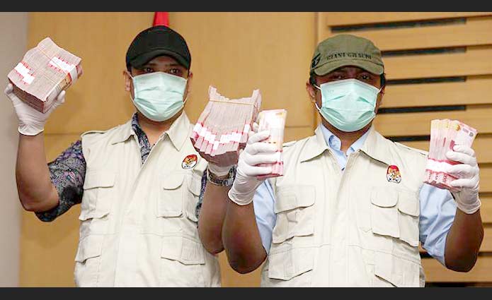 Penyidik saat menunjukkan uang hasil OTT yang melibatkan panitera Pengadilan Negeri Jakarta Utara, di Gedung KPK, Jakarta, Kamis (16/6). Dalam OTT tersebut diamankan barang bukti berupa uang sejumlah Rp 250 juta, serta 4 orang yang ditetapkan sebagai tersangka. foto: kompas.com