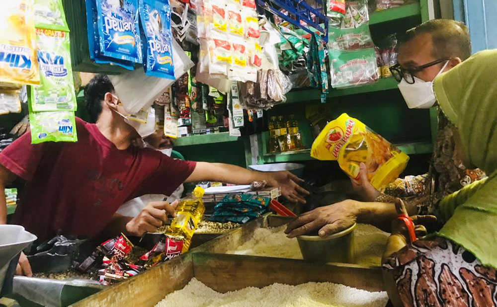 Petugas Disperindag Kabupaten Mojokerto saat memantau harga minyak goreng di salah satu kios.