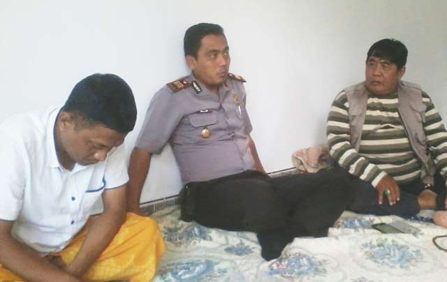 Turmudi (menunduk) didampingi Kapolsek Kadur.