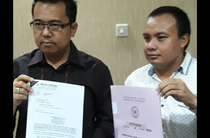 Pengacara M. Sholeh dan kliennya Noval Ibrohim Salim menunjukkan surat somasi ke Presiden dan surat putusan MA yang membatalkan pungutan biaya pengesahan STNK. Foto: Didi Rosadi/BANGSAONLINE