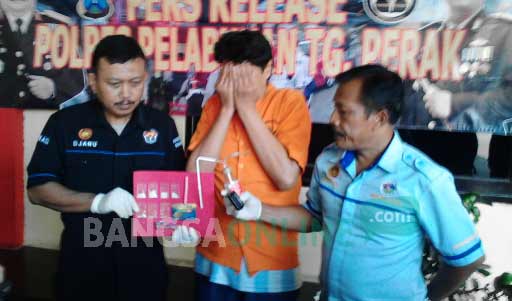 Petugas menunjukan barang bukti dan tersangka yang diamankan di mapolres Tanjung Perak Surabaya. ft:ekoyono/ BANGSAONLINE