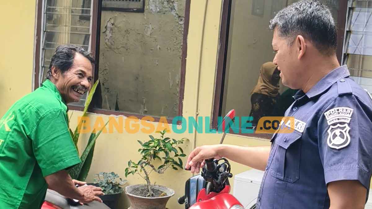 Kasi Humas Polsek Pesantren, Aipda Prisma Nugroho (kanan) dan Suparlan, pemilik sepeda motor. Foto: MUJI HARJITA/BANGSAONLINE