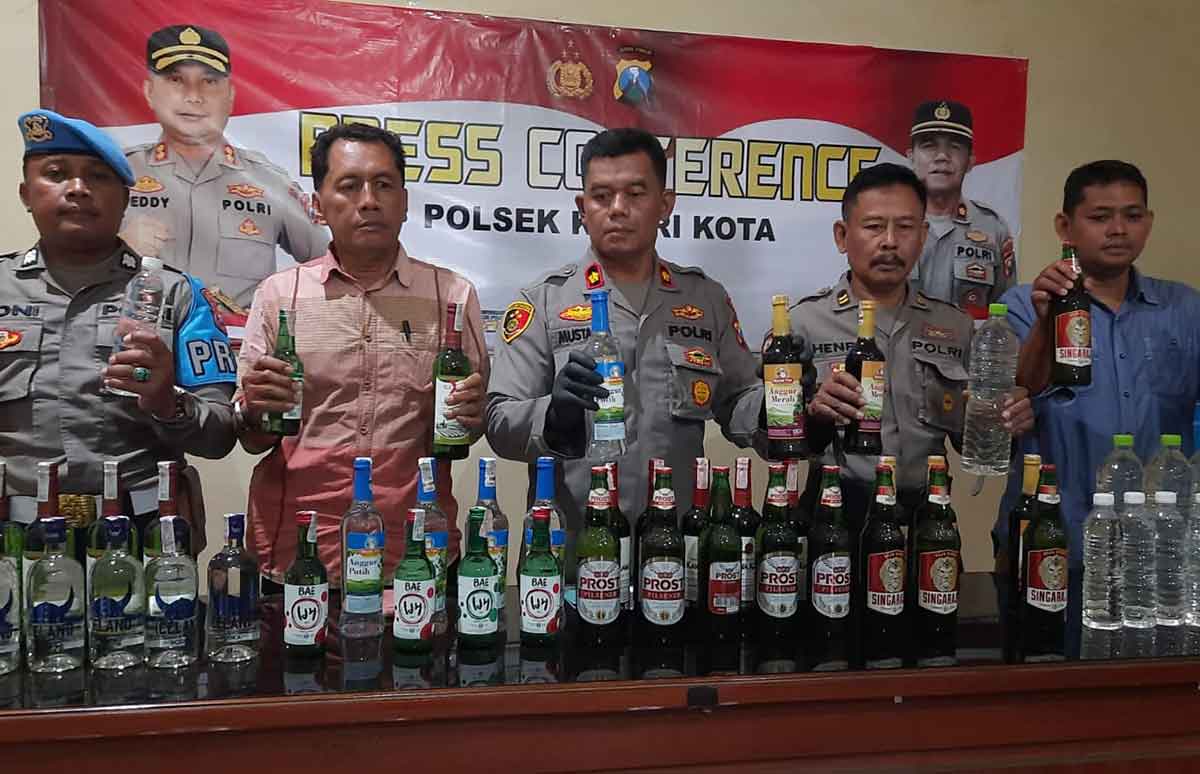 Kapolsek Kota Kediri, Kompol Mustakim (tengah), bersama jajaran saat menunjukkan barang bukti berupa ratusan botol miras berbagai merek. Foto: Ist