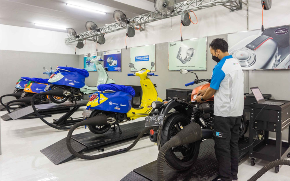 Seorang teknisi Piaggio sedang memeriksa kendaraan pelanggan yang diservis.