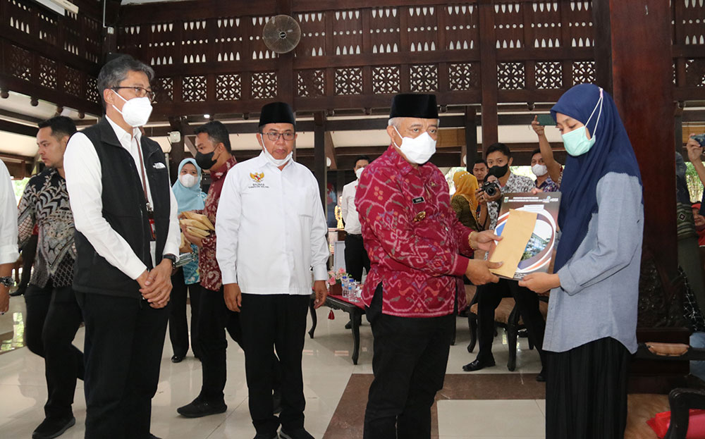 Bupati Malang H. M. Sanusi menyerahkan santunan dari Bank Jatim secara simbolis kepada keluarga korban tragedi Kanjuruhan.