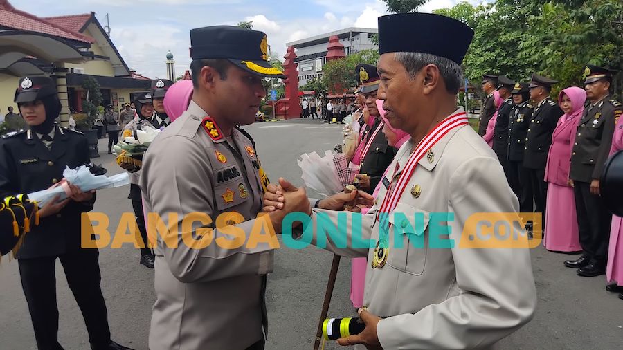 Kapolres Madiun Kota mengkalungkan tanda mata dan beri salam perpisahan. Foto: Hendro Suhartono/BANGSAONLINE