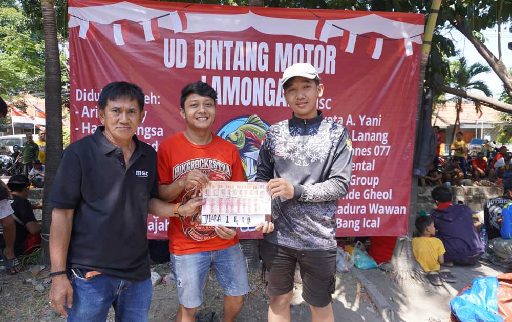 Pimpinan Perusahaan BANGSAONLINE Revol Afkar (tengah) didampingi Ketua Panitia Budi Rahmad (kiri), menyerahkan hadiah kepada juara 1 lomba mancing. Foto: YUSUF/ BANGSAONLINE