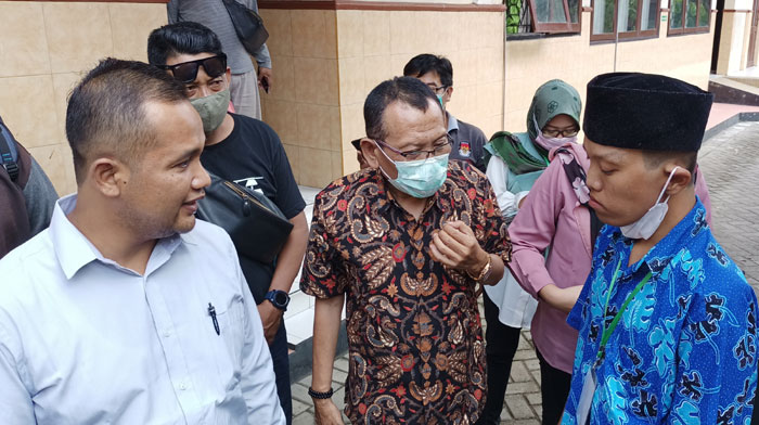 Ani Chasanah alias Anang Sutomo (kanan pakai kopiah) didampingi pengacaranya, Luka Fardani (kiri) dan Danan Prabandaru (tengah). foto: MUJI HARJITA/ BANGSAONLINE