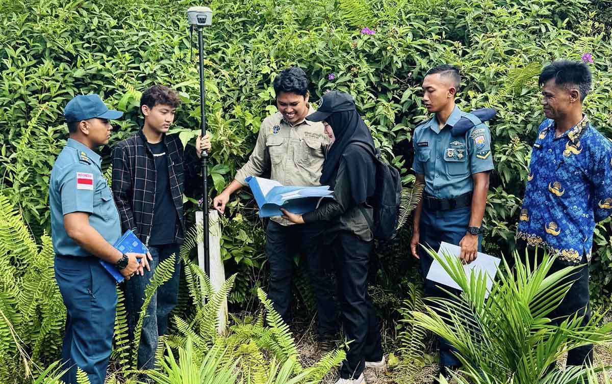Petugas saat mengukur tanah. 