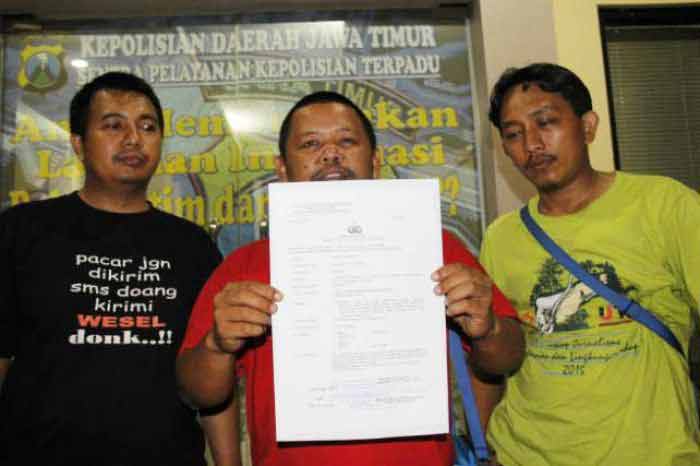Wawan Sugiarto (tengah) wartawan TV One menunjukkan surat laporannya. foto: bruriy suarasurabaya
